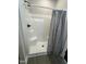 Shower stall with a step and modern dark hardware at 151 E Washington St, Coats, NC 27521