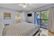 Comfortable bedroom featuring a queen bed, ceiling fan, and access to an outdoor deck at 171 Springberry Ln, Chapel Hill, NC 27517