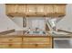 Close-up of the kitchen sink, wood cabinets, and granite countertops opening to the dining room at 171 Springberry Ln, Chapel Hill, NC 27517