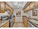 Well-lit kitchen featuring stainless appliances, granite countertops, and wood cabinetry at 171 Springberry Ln, Chapel Hill, NC 27517