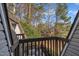 View from a brown wooden railed deck showing trees, rooftops, and outdoor furniture below at 171 Springberry Ln, Chapel Hill, NC 27517