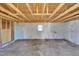 Unfinished basement with exposed ceiling beams, concrete walls, and a small window at 210 Circle Dr, Smithfield, NC 27577