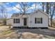 Charming white home featuring black shutters, a cozy front porch, and well-maintained landscaping at 210 Circle Dr, Smithfield, NC 27577