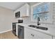 Modern kitchen featuring stainless steel appliances, white cabinetry, and a bright window at 210 Circle Dr, Smithfield, NC 27577