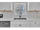 Bright kitchen with white cabinets, stainless steel sink, and large window for ample natural light at 210 Circle Dr, Smithfield, NC 27577