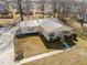 Aerial shot showcases a cozy home with a metal roof, front porch, and driveway at 231 Patterson Dr, Roxboro, NC 27573