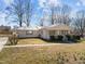 Single-story home with a metal roof, quaint front porch, and manicured lawn at 231 Patterson Dr, Roxboro, NC 27573
