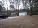 Two outbuildings offer versatile storage space on a wooded lot; black car parked nearby at 2506 Poole Rd, Raleigh, NC 27610
