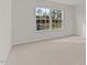 Bright bedroom featuring a window with views of the outdoors and plush carpeting at 2561 Summersby Dr, Mebane, NC 27302