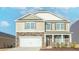 Charming two-story home featuring a stone and siding exterior with an attached two-car garage at 2561 Summersby Dr, Mebane, NC 27302