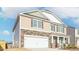 Two-story home featuring stone and siding, two car garage, and a covered front porch at 2561 Summersby Dr, Mebane, NC 27302