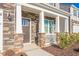Close-up of the inviting front porch with stone accents, white pillars, and well-maintained landscaping at 2561 Summersby Dr, Mebane, NC 27302