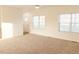 Bright and airy living room featuring neutral carpeting, white trim, and a ceiling fan at 29 Hinshaw Shop Rd, Liberty, NC 27298