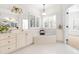 Bright bathroom featuring a soaking tub, plantation shutters, and a double sink vanity at 2909 Hawtree Dr, Raleigh, NC 27613