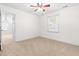 Carpeted bedroom with fan and window featuring neutral walls and trim with an entrance to another room at 2909 Hawtree Dr, Raleigh, NC 27613