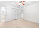 Neutral carpeted bedroom features a ceiling fan and closet with double doors, leading to a light-filled bathroom at 2909 Hawtree Dr, Raleigh, NC 27613