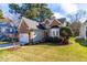Charming brick home featuring an attached garage, manicured lawn, and mature trees for added curb appeal at 2909 Hawtree Dr, Raleigh, NC 27613