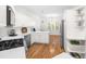 Bright kitchen features white cabinetry, stainless steel appliances, and hardwood floors at 2909 Hawtree Dr, Raleigh, NC 27613