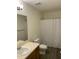 Standard bathroom with a single sink vanity, toilet, mirror, and shower with patterned curtain at 309 Gladstone Dr, Durham, NC 27703