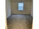 Well-lit bedroom features neutral carpet and window overlooking backyard at 309 Gladstone Dr, Durham, NC 27703