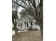 A quaint single-story home with neutral siding, accented by black shutters and green shrubbery near the front entrance at 309 Gladstone Dr, Durham, NC 27703