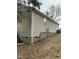 Side of home featuring neutral vinyl siding, gray brick foundation, small window, and utilities at 309 Gladstone Dr, Durham, NC 27703