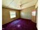 This bedroom features purple carpet, a ceiling fan, and a window with lots of natural light at 328 Cone Dr, Henderson, NC 27537