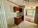 Compact kitchen area showcases ample cabinetry, unique wallpaper, and an adjacent room at 328 Cone Dr, Henderson, NC 27537