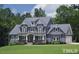 Beautiful two-story home with stylish blue siding, gabled roof, and a well-manicured front lawn at 405 Fieldstone Ln, Pittsboro, NC 27312