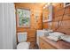 Cozy bathroom featuring wood paneling, a toilet, a sink, and a vanity with fresh, white towels at 409 S 13Th St, Lillington, NC 27546