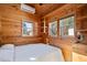 Charming bedroom showcasing wood paneling, bright natural light, and a comfortable bed with crisp white linens at 409 S 13Th St, Lillington, NC 27546