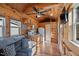 Inviting living room featuring wood paneling, a fan, a sofa, and a compact kitchen with modern appliances at 409 S 13Th St, Lillington, NC 27546