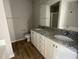 Bathroom featuring double sinks, granite countertops, white cabinets, and a large mirror at 42 Heatherglenn Cir, Princeton, NC 27569