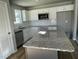Bright kitchen featuring a kitchen island with granite countertops and stainless steel appliances at 42 Heatherglenn Cir, Princeton, NC 27569