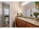 Well-lit bathroom with a large mirror, granite countertop, wood cabinets, and walk-in toilet at 4278 Aviemore, Burlington, NC 27215