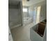 Bright bathroom featuring a white tub-shower, window, and white cabinets awaiting countertops for storage at 432 E Clydes Point Way, Wendell, NC 27591