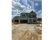New construction home featuring gray siding, black shutters, and a three-car garage on a sunny day at 432 E Clydes Point Way, Wendell, NC 27591