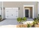 Welcoming front entrance featuring a one-car garage, landscaping, and a dark wood front door at 45 Ripple Way Way, Clayton, NC 27520