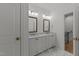 Bathroom with double vanity, framed mirrors, and marble tile flooring at 4501 Bartlett Dr, Raleigh, NC 27609