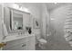 Bathroom with a double vanity, decorative mirror and marble tiled shower with glass enclosure at 4501 Bartlett Dr, Raleigh, NC 27609