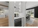 Butler's pantry with white cabinets, wine cooler, marble countertops, and glass shelving with decor at 4501 Bartlett Dr, Raleigh, NC 27609