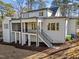 Back exterior view showing large deck, stairs, and white painted brick at 4501 Bartlett Dr, Raleigh, NC 27609