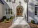 An elegant arched entryway with a striking wooden double door and stone steps at 4501 Bartlett Dr, Raleigh, NC 27609