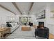 Bright living room with exposed beam ceiling, fireplace, and sliding glass doors to the balcony at 4501 Bartlett Dr, Raleigh, NC 27609