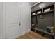 A well-organized mudroom featuring a built-in bench with storage cabinets, hooks, and a light hardwood floor at 4501 Bartlett Dr, Raleigh, NC 27609