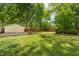 Lush backyard with manicured lawn, mature trees, and a detached garage at 531 N Main St, Graham, NC 27253
