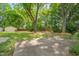 Spacious backyard featuring mature trees, lush grass, and a concrete patio with benches at 531 N Main St, Graham, NC 27253