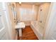 Bathroom featuring a pedestal sink, tub with shower, and plantation shutters at 531 N Main St, Graham, NC 27253