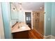 Bathroom featuring a double vanity with a granite countertop, and a tiled walk-in shower at 531 N Main St, Graham, NC 27253