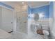 Bright bathroom with walk-in shower, blue walls, and white tile floor at 531 N Main St, Graham, NC 27253